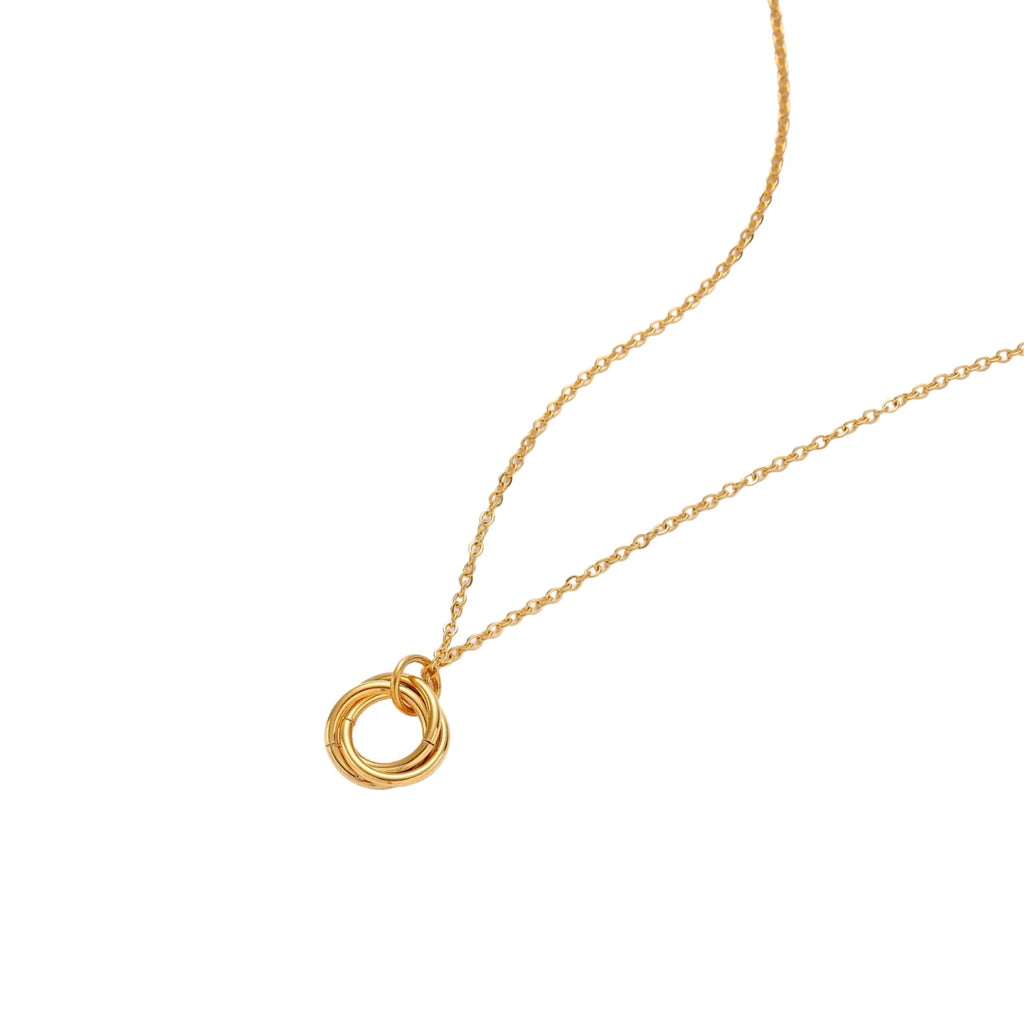 Delicate gold-plated necklace with three interlocking circle rings forming a minimalist knot pendant on cream background