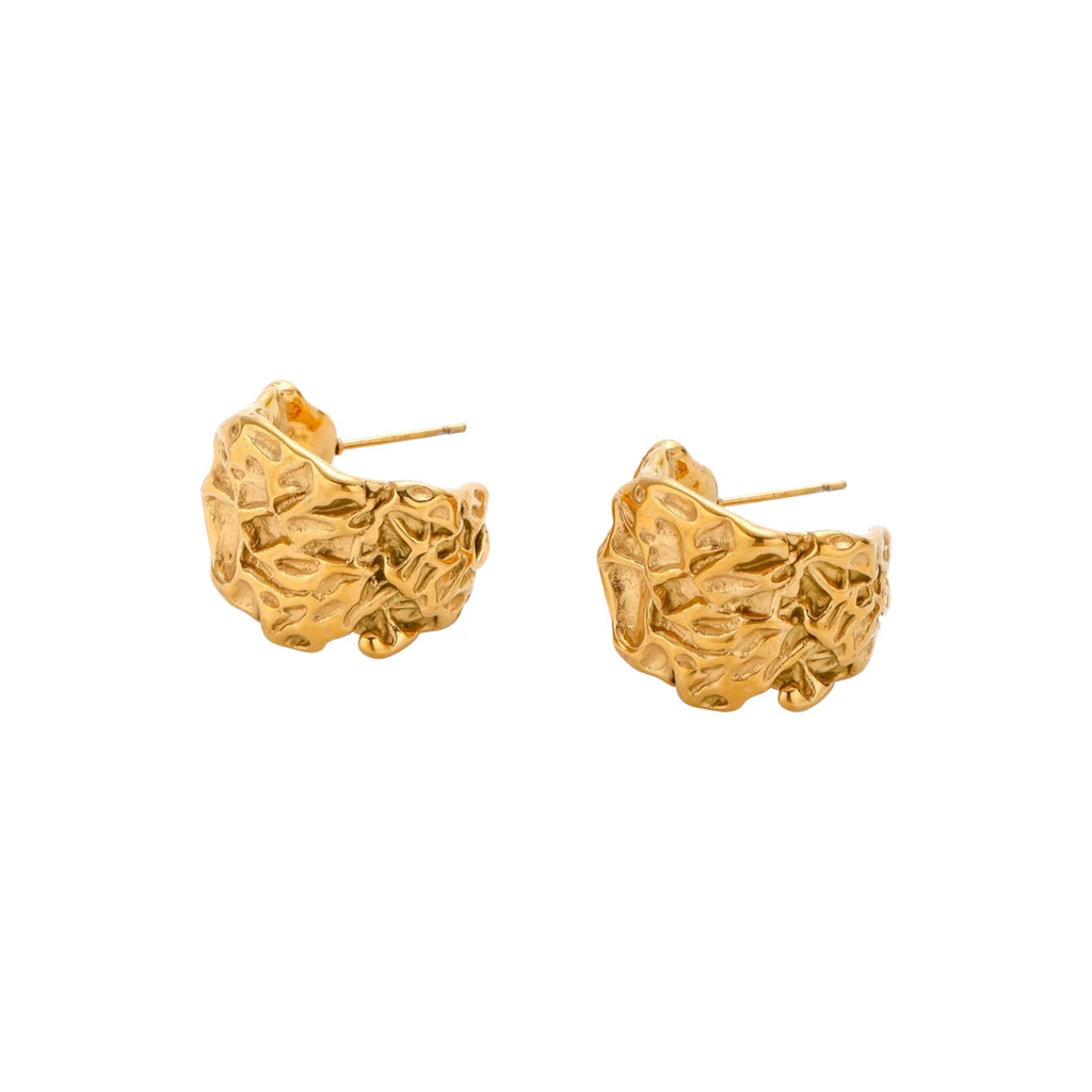 Sculptural gold-plated hoops with organic crushed texture on cream background