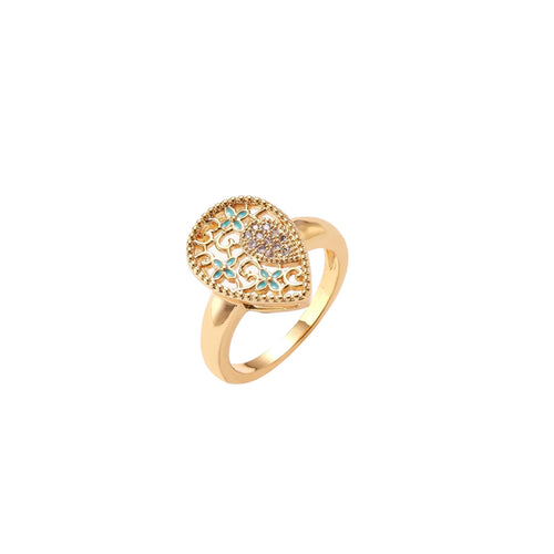 Teardrop-shaped gold-plated ring with turquoise enamel flowers and crystal pavé detail on cream background
