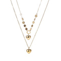 Three-layer 14K gold plated necklace with coin discs and dual heart pendants on cream background