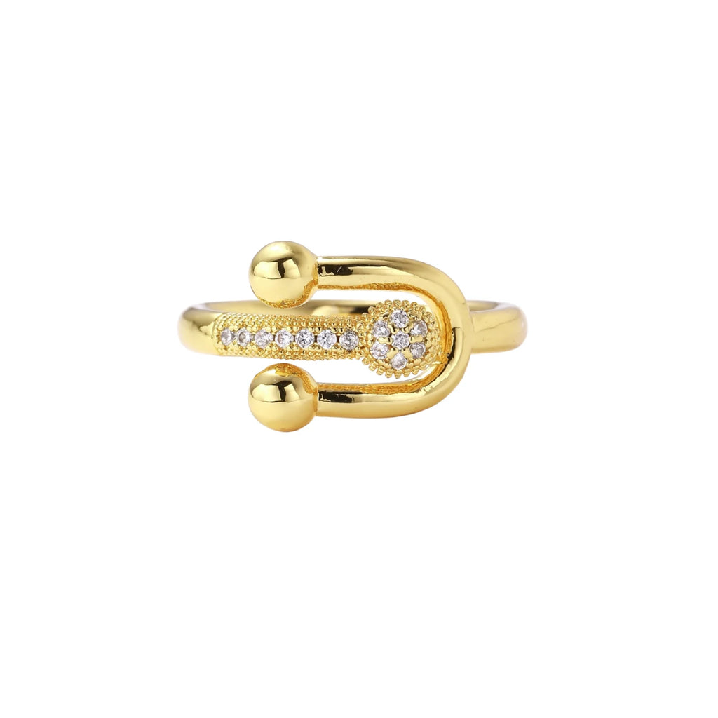Gold-plated brass ring with safety pin design featuring pavé cubic zirconia stones and dual sphere ends