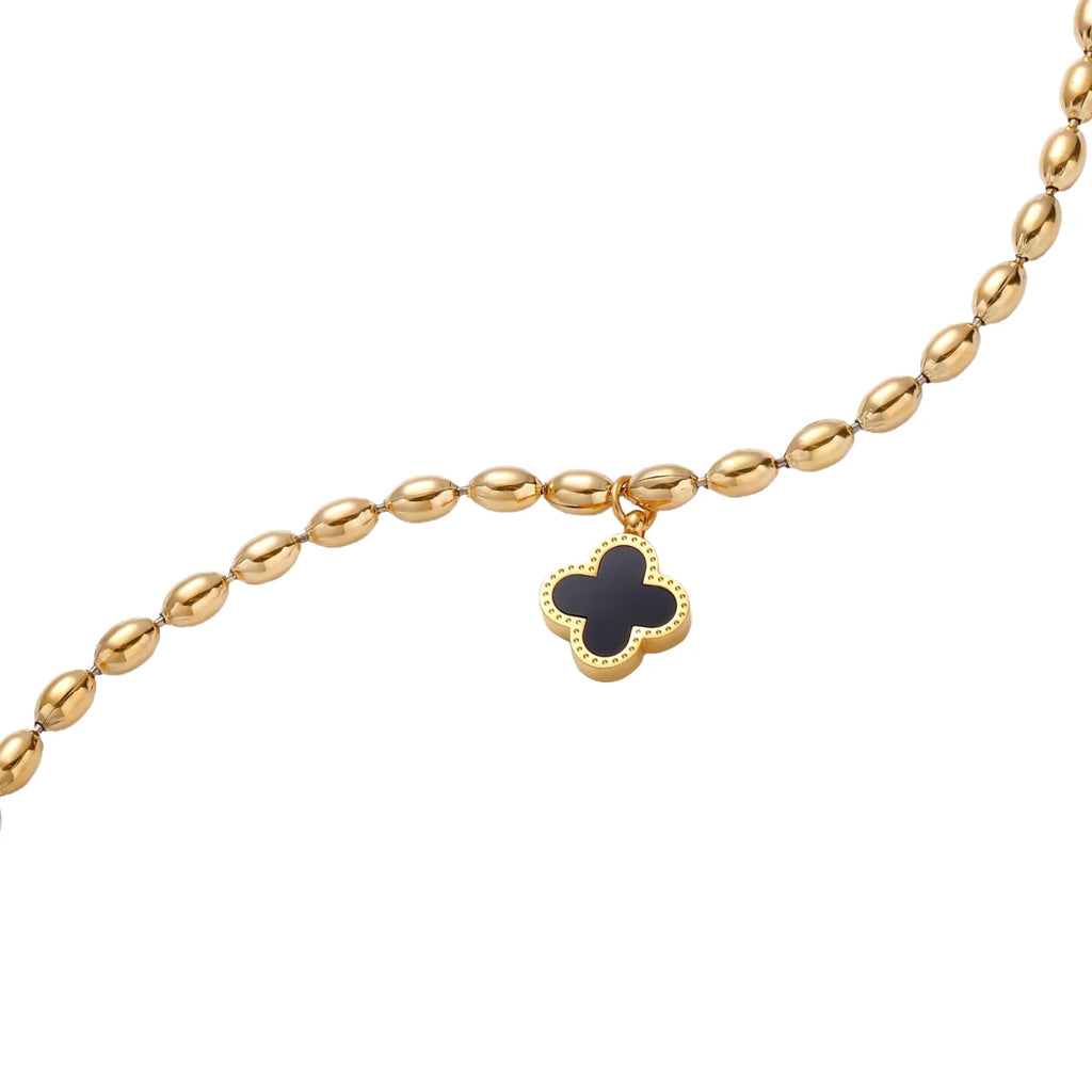 18K gold-plated oval bead chain bracelet with quatrefoil clover charm featuring mother of pearl inlay on cream background