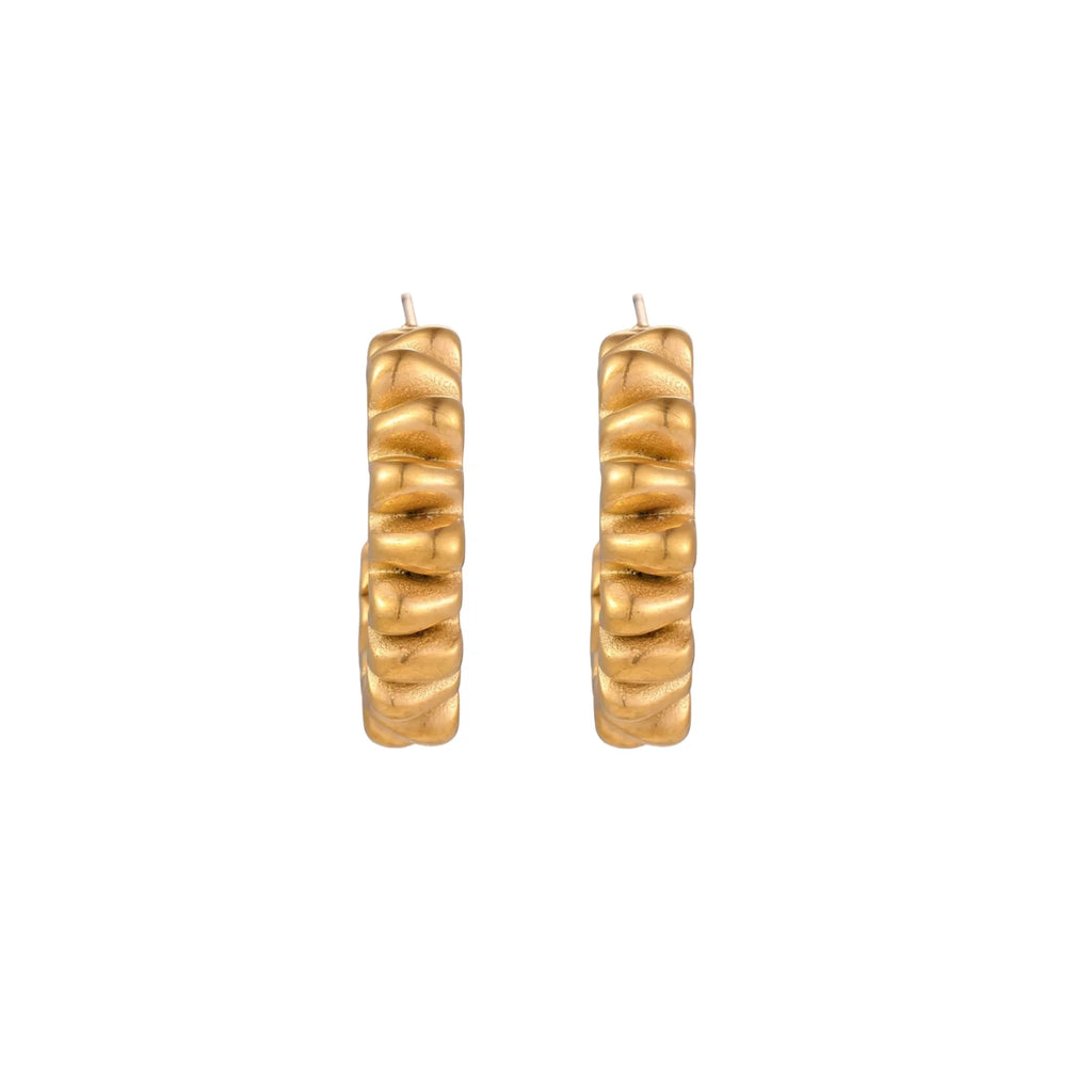 Sculptural gold-plated hoop earrings with continuous twisted spiral design on cream background