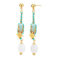 Gold-plated dangle earrings with turquoise threading, star charms, and white pearl beads against cream background.