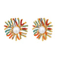 Vibrant starburst stud earrings with multicolor enamel rays and white pearl centers on gold-plated setting