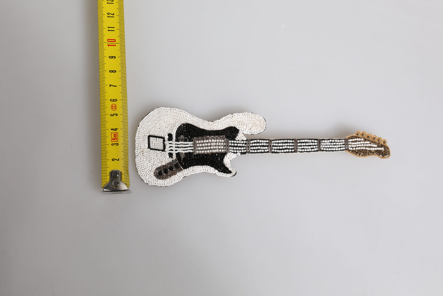 Broche de alfiler de guitarra con logo de latón dorado y abalorios Dolce & Gabbana